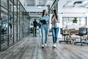 Bureaux avec des cloisons vitrées lumineux avec deux femmes qui marchent